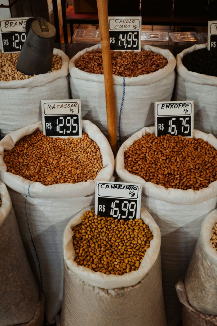 Colorful beans in sacks with price tags at a market in Brazil. Vibrant and diverse selection.